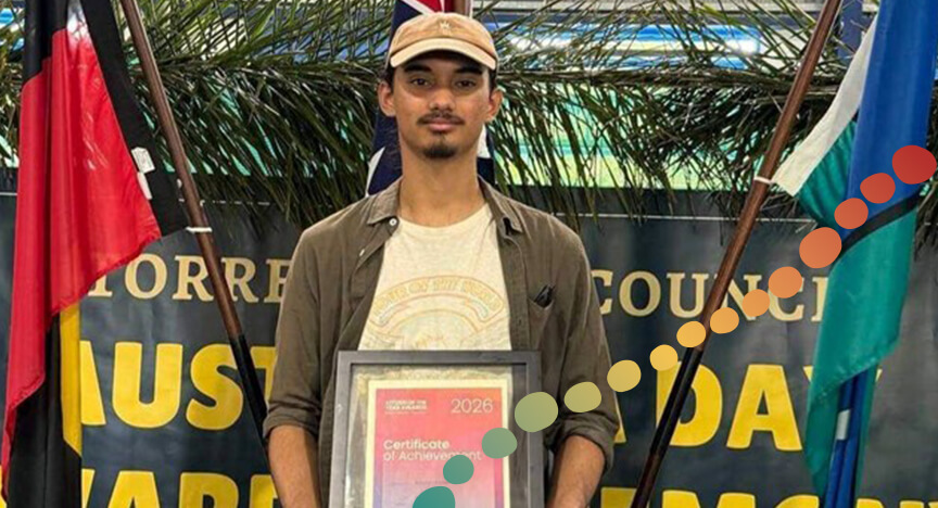 Teenage boy standing in front of flags, holding a certificate