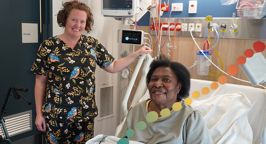 A person standing next to a patient in bed.