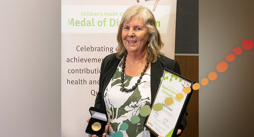 Woman standing, holding a certificate and medal
