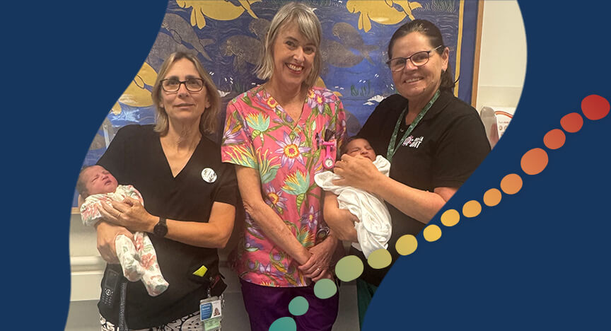 3 women, with 2 of them holding newborn babies