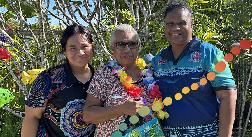 3 smiling women standing together is front of plants